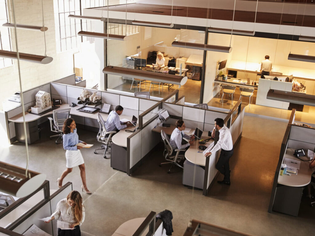 Busy commercial office with employees working at cubicles, showing higher foot traffic