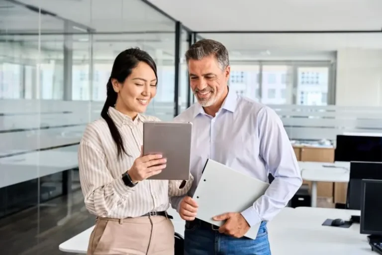 Facility manager and colleague reviewing a commercial cleaning quote on a tablet
