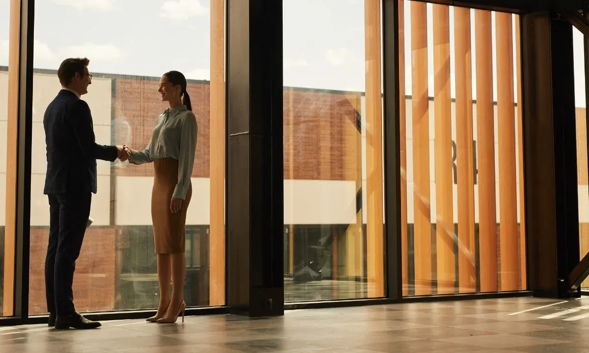 Business owner shaking hands with a commercial cleaning estimator in an office lobby